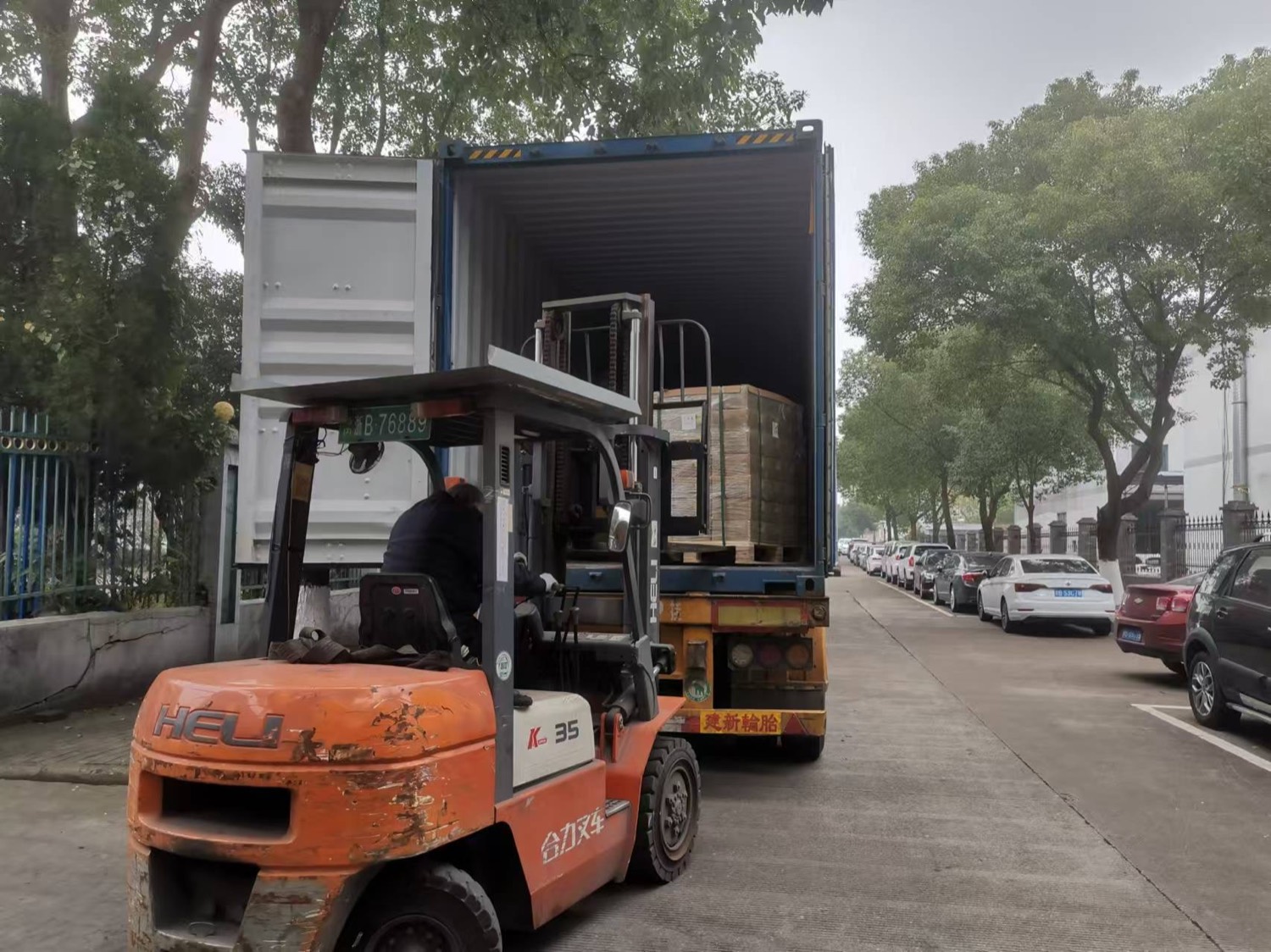 Forklift loading pallets into an export shipping container
