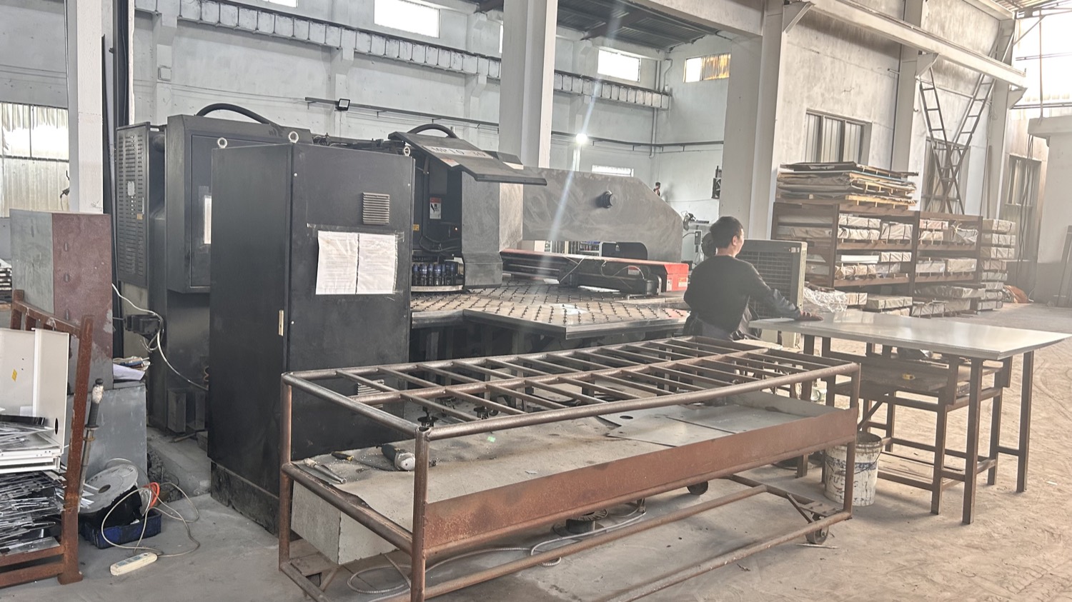 Operator feeding sheet metal into a CNC punching machine