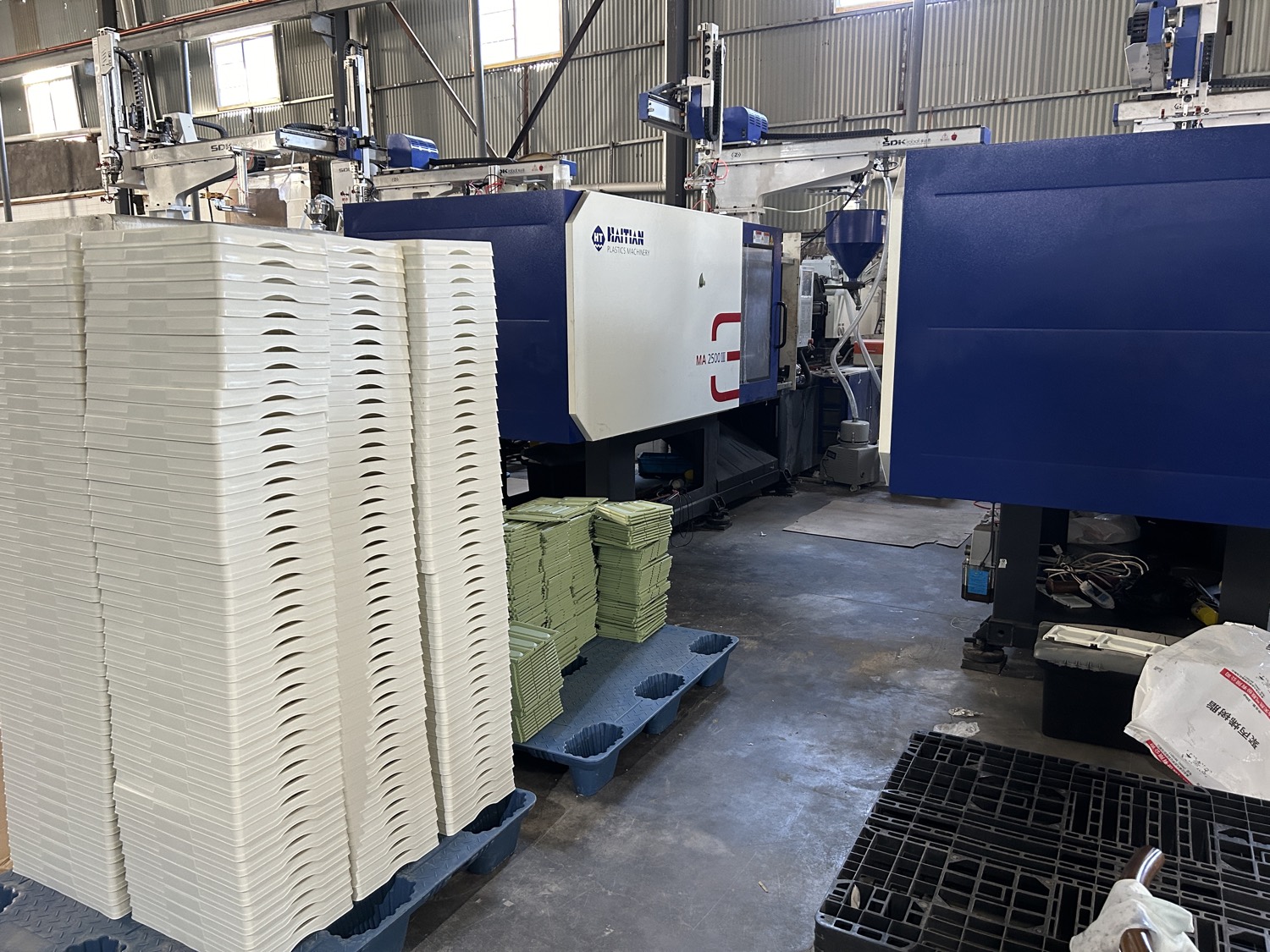Second injection moulding cell with moulded parts stacked alongside